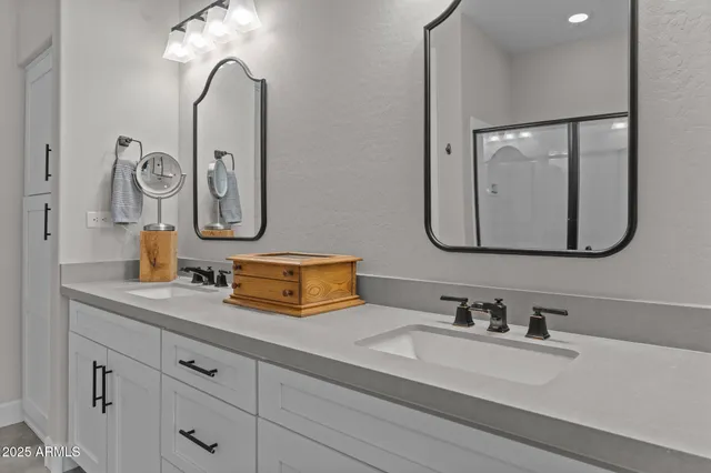 a bathroom with double vanity sinks and a mirror
