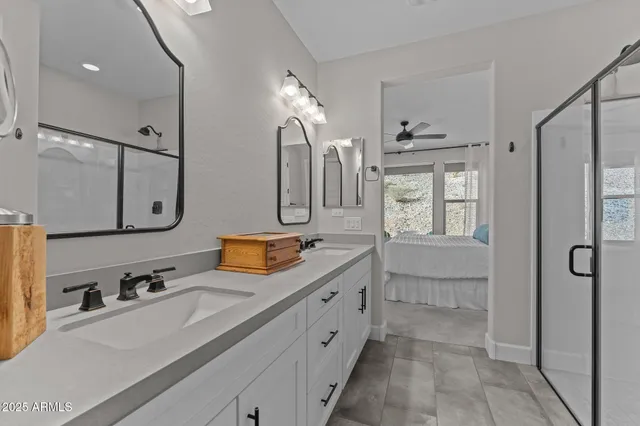 a spacious bathroom with double vanity sink a mirror a vanity and shower