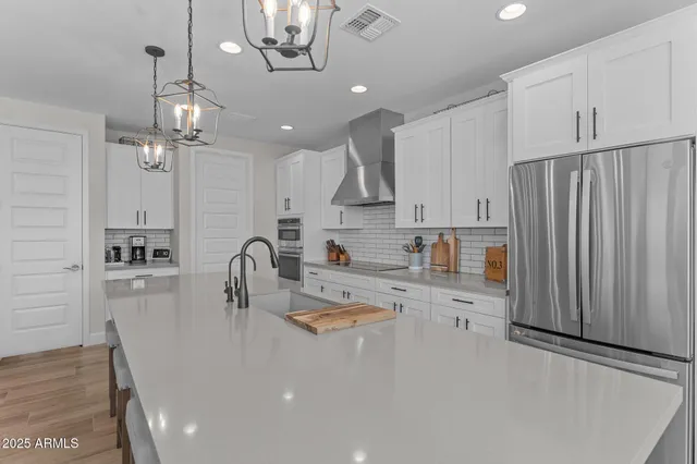 a kitchen with stainless steel appliances granite countertop a sink refrigerator and cabinets