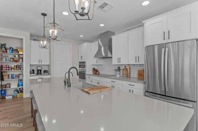 a kitchen with stainless steel appliances granite countertop a sink refrigerator and cabinets