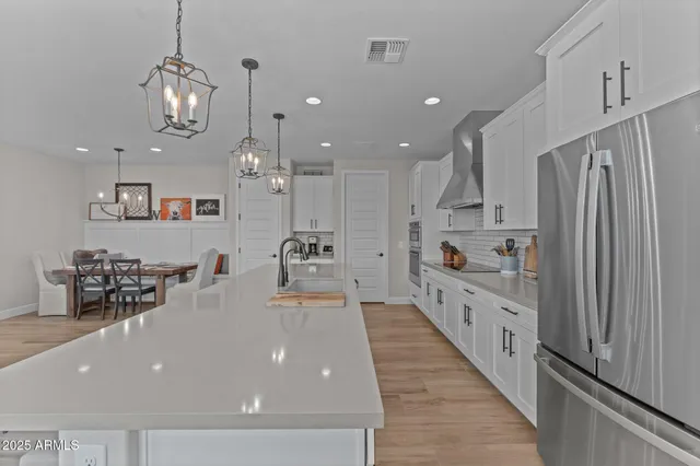 a large kitchen with stainless steel appliances a large counter top a stove and a refrigerator