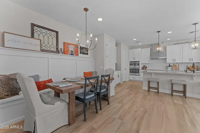 a open dining room with stainless steel appliances kitchen island granite countertop a table chairs and a microwave