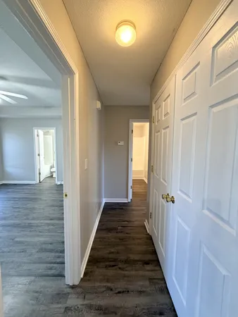 a view of a hallway with wooden floor