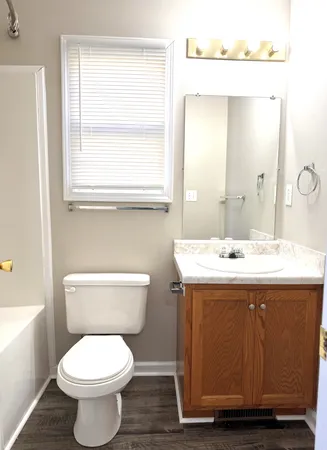 a bathroom with a toilet sink and mirror