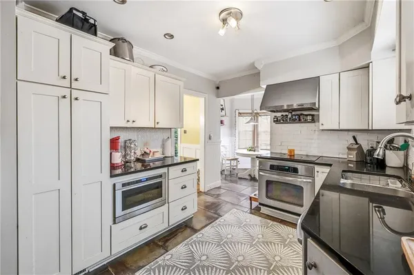 a kitchen with granite countertop a sink stove and refrigerator