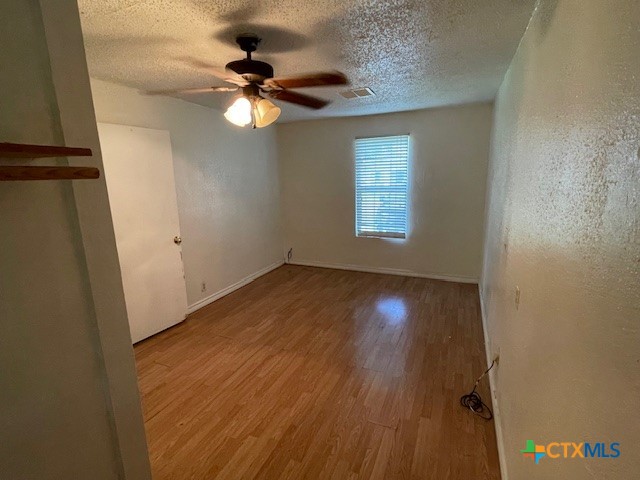210 Carter Street Killeen, TX 76541 - Photo 9 of 11 a view of an empty room with wooden floor and a window