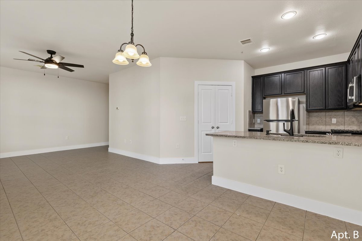 2225 Katy Lane, Unit B Georgetown, TX 78626 - Photo 7 of 22 Kitchen featuring light stone countertops, backsplash, hanging lights, ceiling fan, and stainless steel appliances