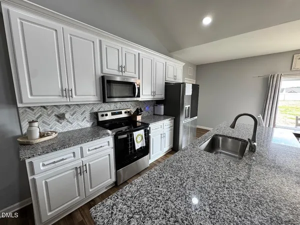 a kitchen with stainless steel appliances granite countertop microwave stove top oven and cabinets