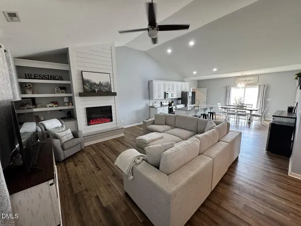 a living room with furniture kitchen view and a fireplace