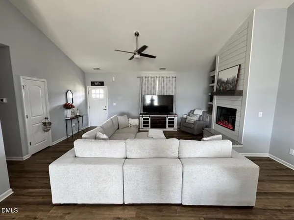 a living room with furniture a fireplace and a flat screen tv
