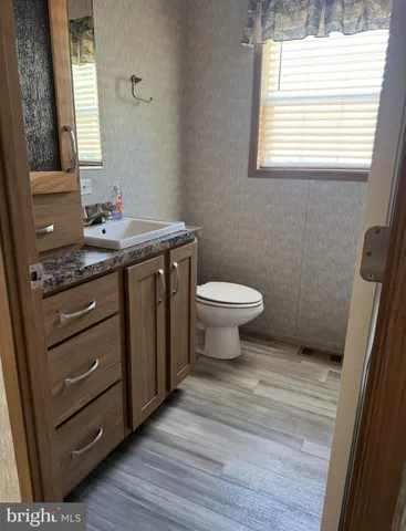 a bathroom with a granite countertop toilet sink and mirror