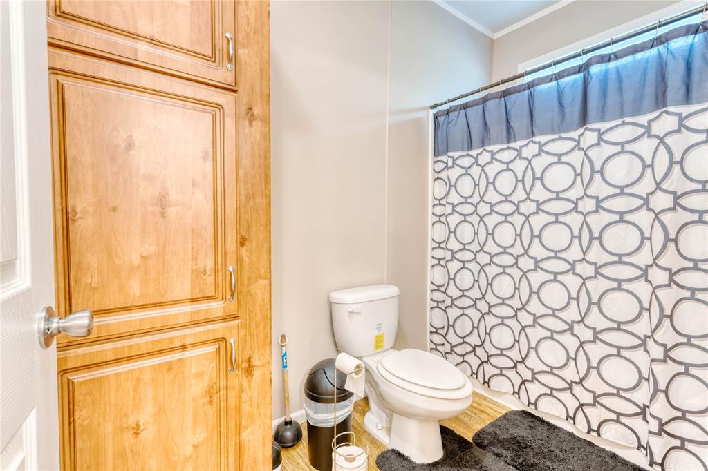 274 Northeast 106th Street Okeechobee, FL 34972 - Photo 16 of 43 a bathroom with a toilet and a shower curtain