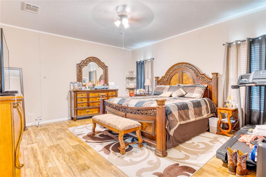 274 Northeast 106th Street Okeechobee, FL 34972 - Photo 18 of 43 a bedroom with a bed and a chandelier