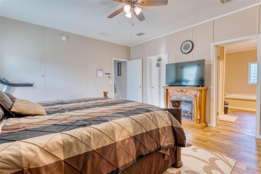 274 Northeast 106th Street Okeechobee, FL 34972 - Photo 21 of 43 a bedroom with a bed and a flat screen tv