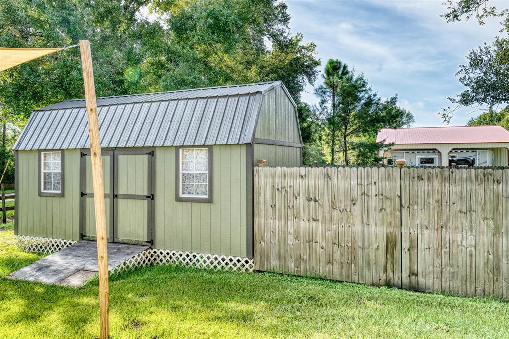 274 Northeast 106th Street Okeechobee, FL 34972 - Photo 42 of 43 a front view of a house having yard with plants and large tree