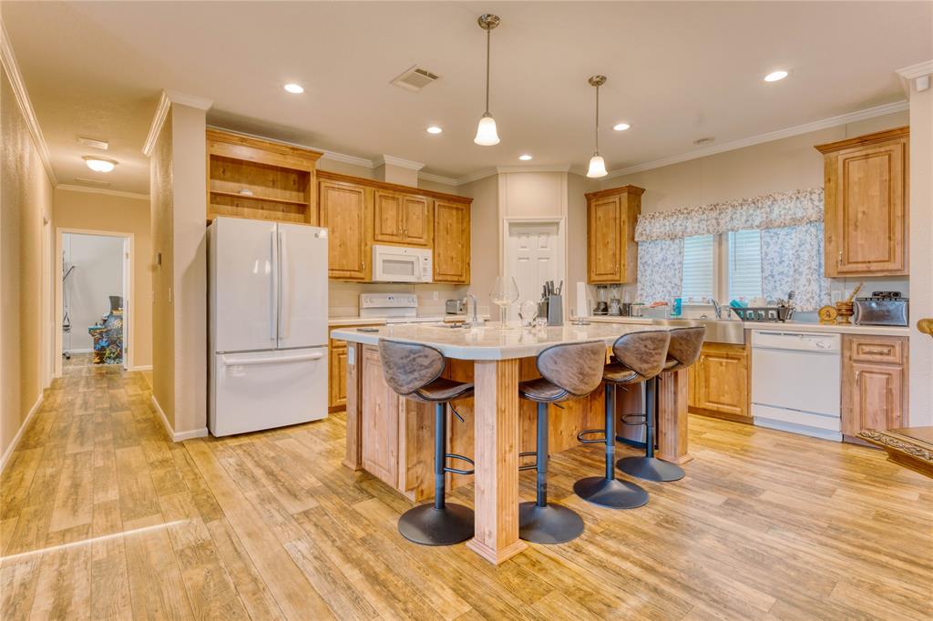 274 Northeast 106th Street Okeechobee, FL 34972 - Photo 9 of 43 a kitchen with stainless steel appliances kitchen island granite countertop a refrigerator a stove a sink and white cabinets with wooden floor