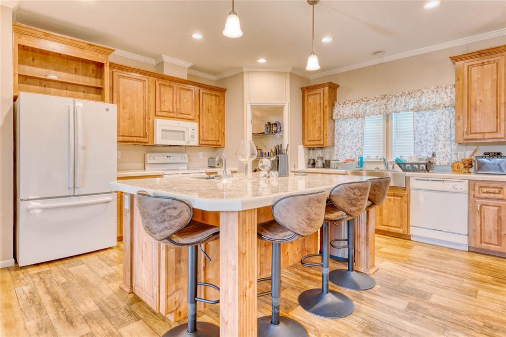 274 Northeast 106th Street Okeechobee, FL 34972 - Photo 10 of 43 a kitchen with stainless steel appliances kitchen island granite countertop a table chairs and a refrigerator