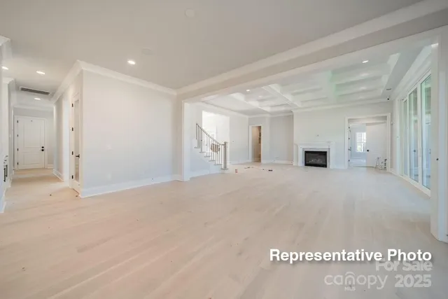 a large white kitchen with kitchen island a sink a stove a refrigerator and a dining table