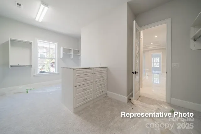 a view of walk in closet with empty racks