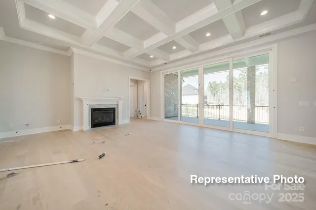 an empty room with windows and fireplace