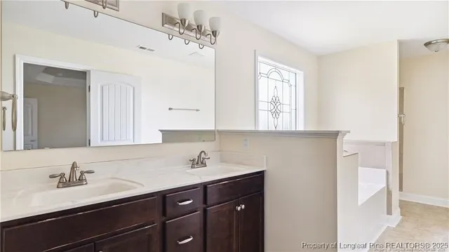 a bathroom with a double vanity sink mirror and cabinets