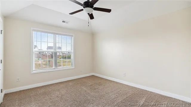 an empty room with a window and a fan