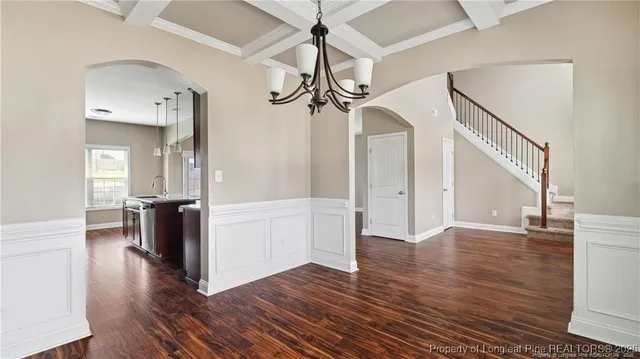 a view of a hallway with wooden floor and cabinets