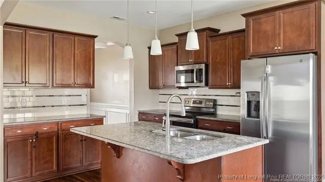 a kitchen with stainless steel appliances granite countertop a sink stove and refrigerator