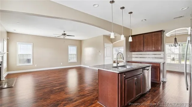 a kitchen with granite countertop a sink stove and wooden floor