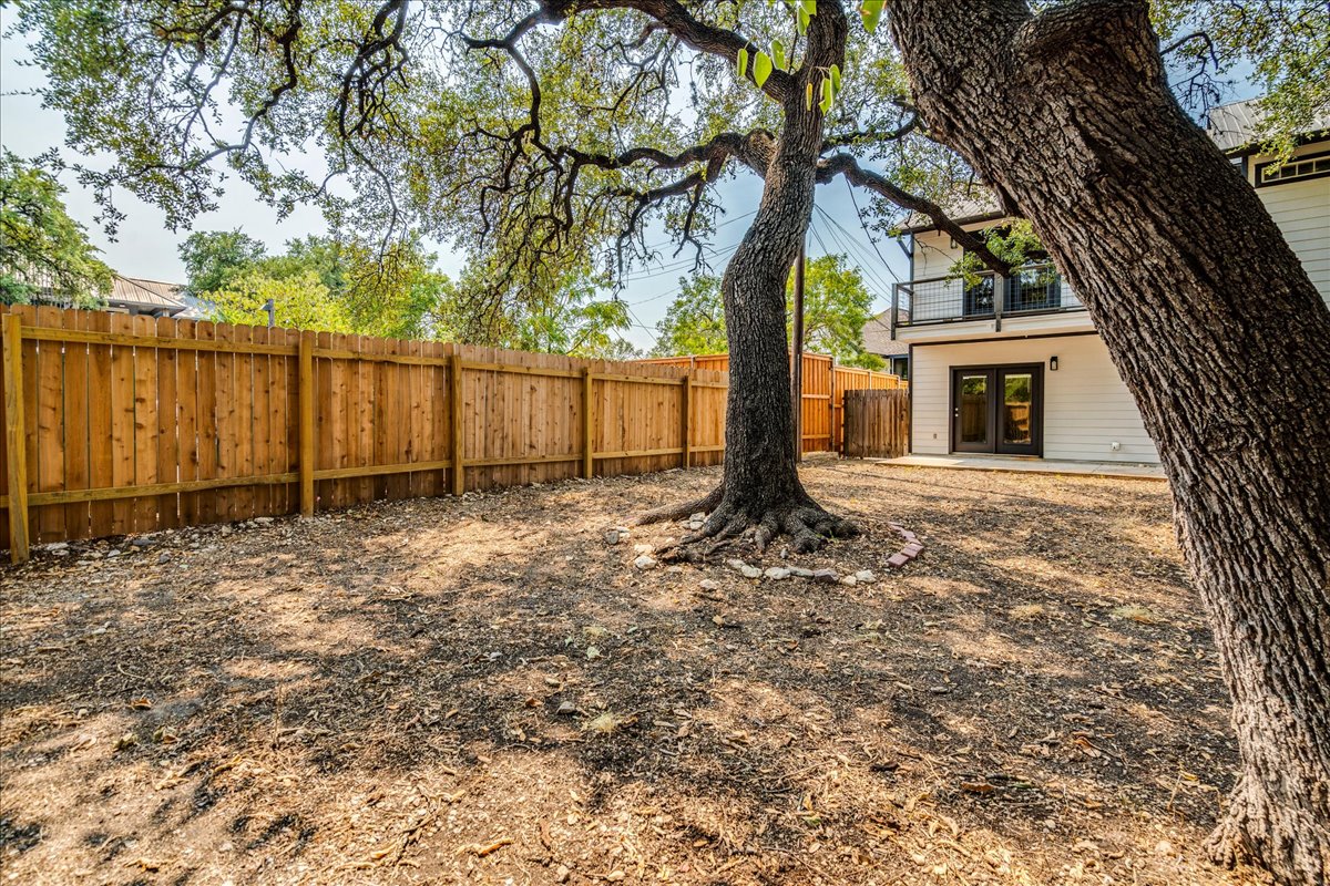 2811 Hardeman Street, Unit B Austin, TX 78704 - Photo 25 of 34 Mature shade trees and a privacy fence frame the outdoor space behind the home.