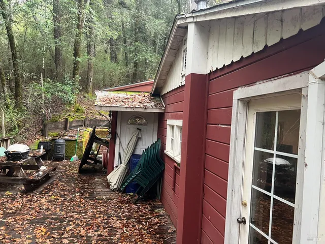 a view of a house with a large window and potted plants