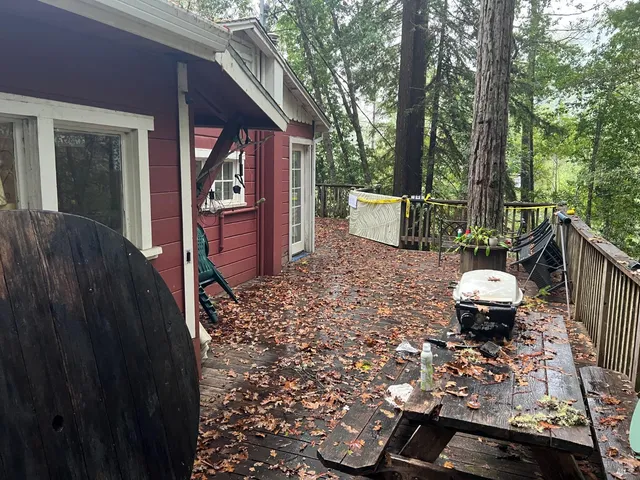 a view of a backyard with table and chairs potted plants with wooden fence
