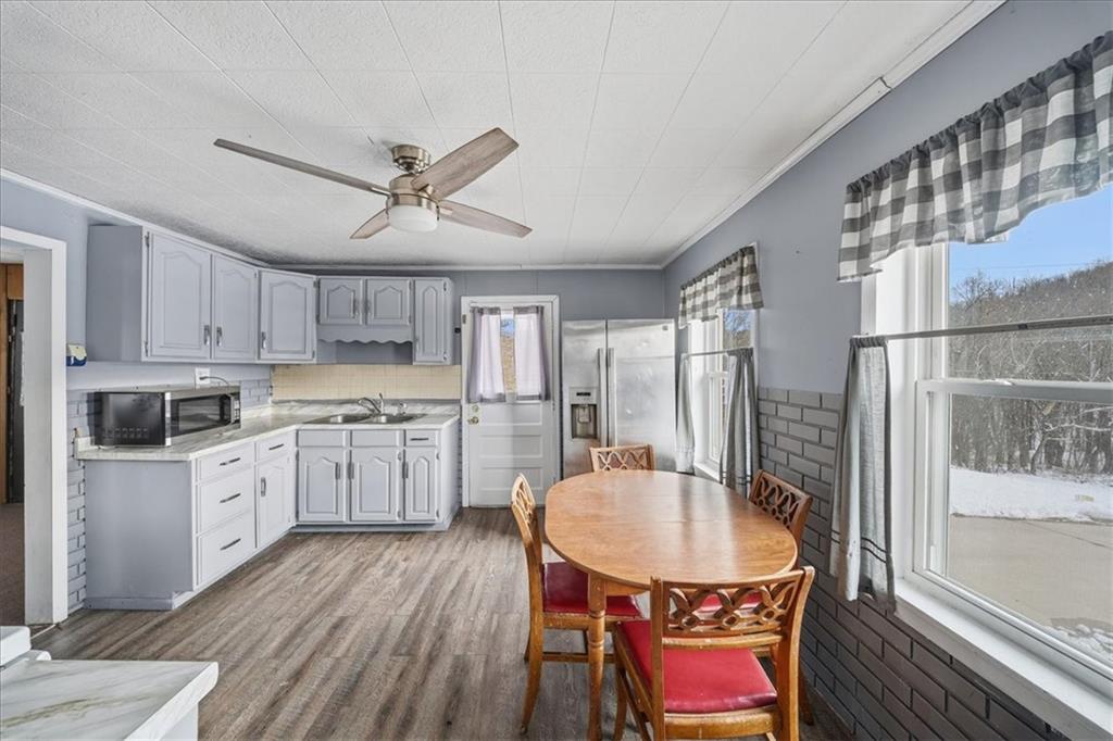 1060 Phillips Street Baden, PA 15005 - Photo 14 of 34 a kitchen with refrigerator a stove a sink dishwasher a dining table and chairs with wooden floor