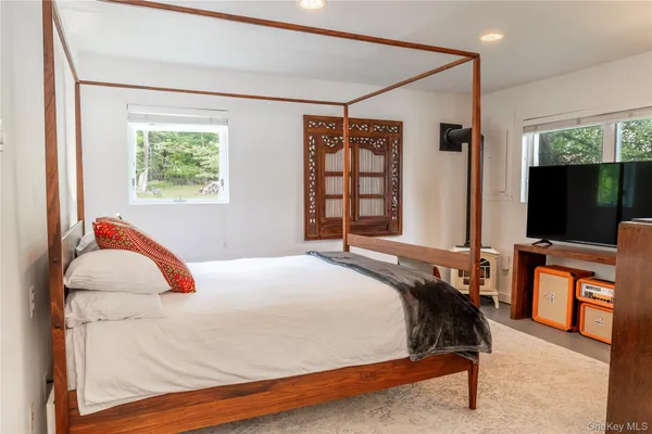 a bedroom with a bed and a large window