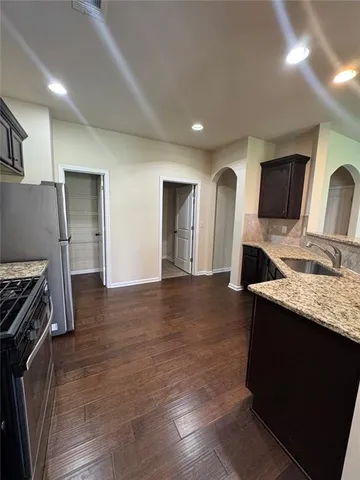 a kitchen with stainless steel appliances granite countertop a sink stove and refrigerator