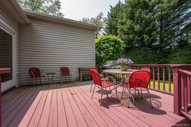 a balcony with wooden floor table and chairs