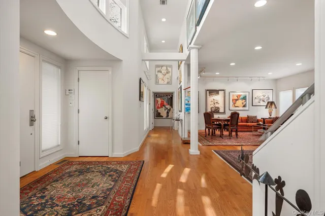 a view of a hallway with furniture and wooden floor