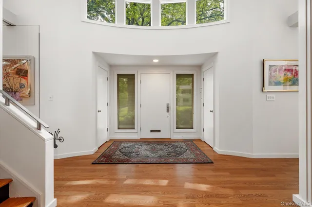 a view of a hallway with wooden floor and a cabinet