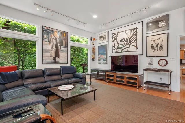 a living room with furniture a flat screen tv and a large window