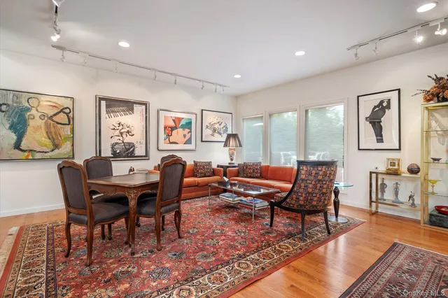 a living room with furniture a rug and a floor to ceiling window