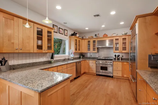 a large kitchen with stainless steel appliances granite countertop a stove and a sink