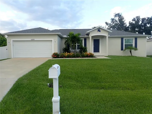 a front view of a house with a garden and yard