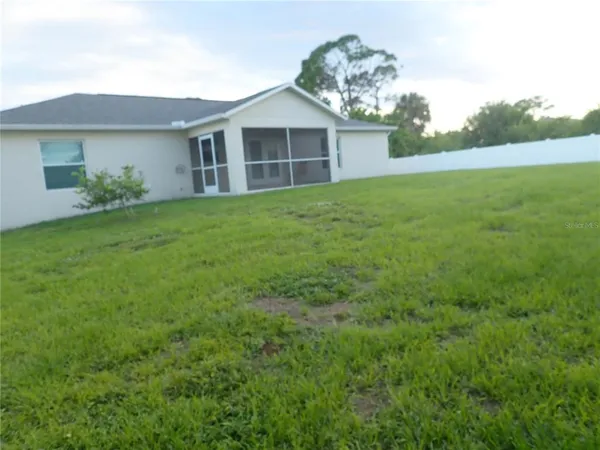 a view of a yard in front of a house with large trees