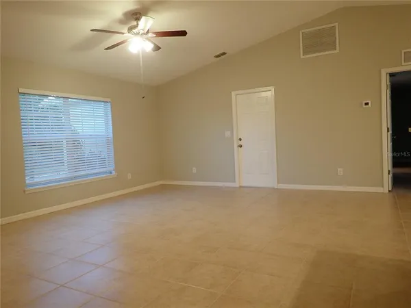 a kitchen with stainless steel appliances granite countertop a sink a stove top oven a refrigerator with white cabinets and a refrigerator