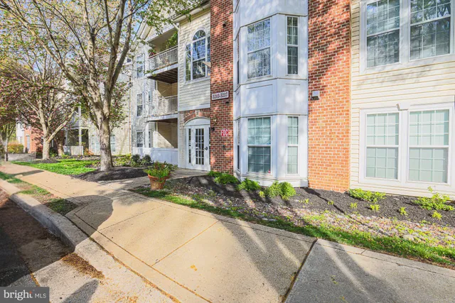 a front view of a house with a yard and potted plants