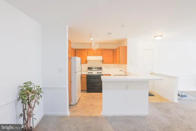 a kitchen with granite countertop a refrigerator stove and sink