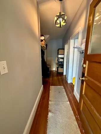 a view of a hallway with wooden floor and staircase