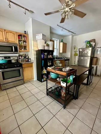 a living room with stainless steel appliances furniture a dining table and a chandelier