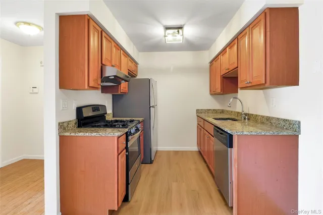 a kitchen with stainless steel appliances granite countertop a stove a sink and a refrigerator