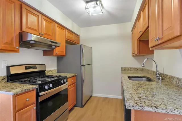 a kitchen with stainless steel appliances granite countertop a sink stove and refrigerator